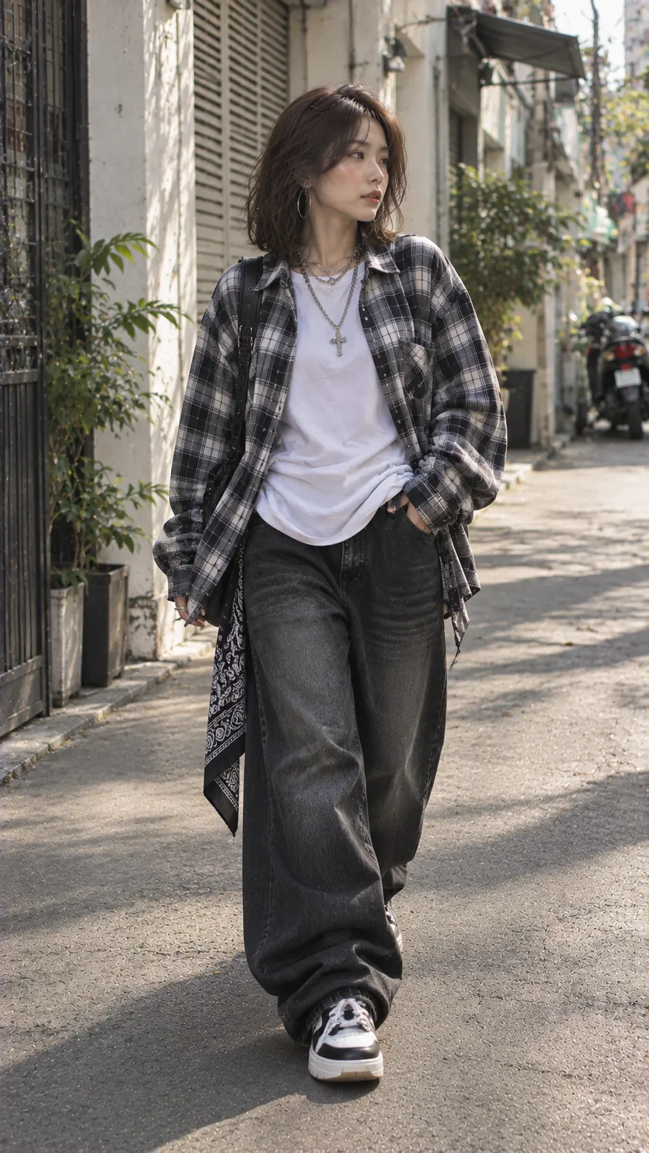 Outfit Chicano nữ với áo thun trắng gọn, quần baggy tối màu và sơ mi rộng khoác ngoài